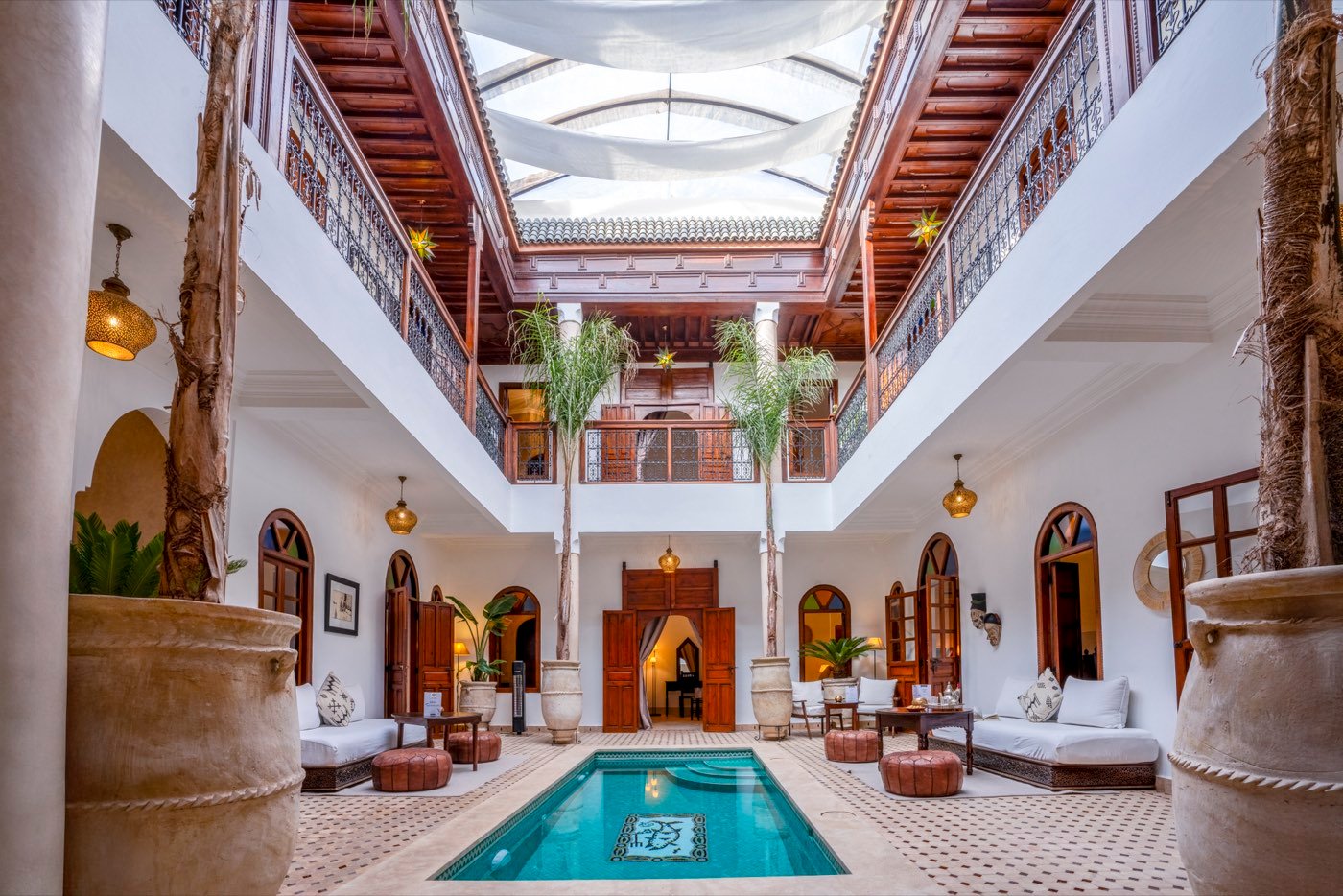 The riad courtyard with its plunge pool, palms and carved cedar galleries