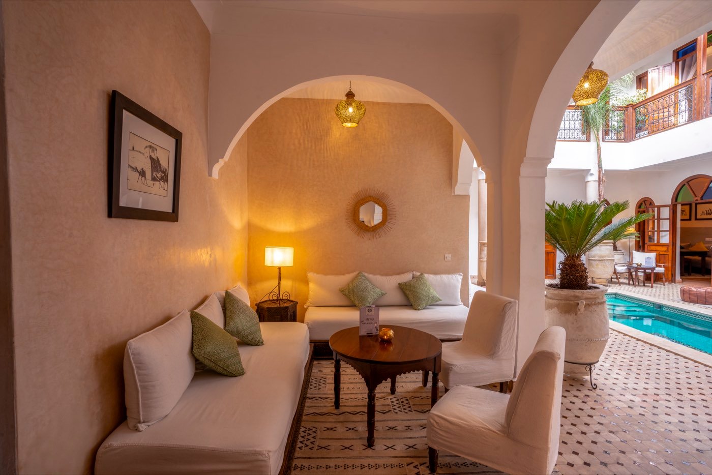 A vaulted alcove of low seating opening onto the courtyard