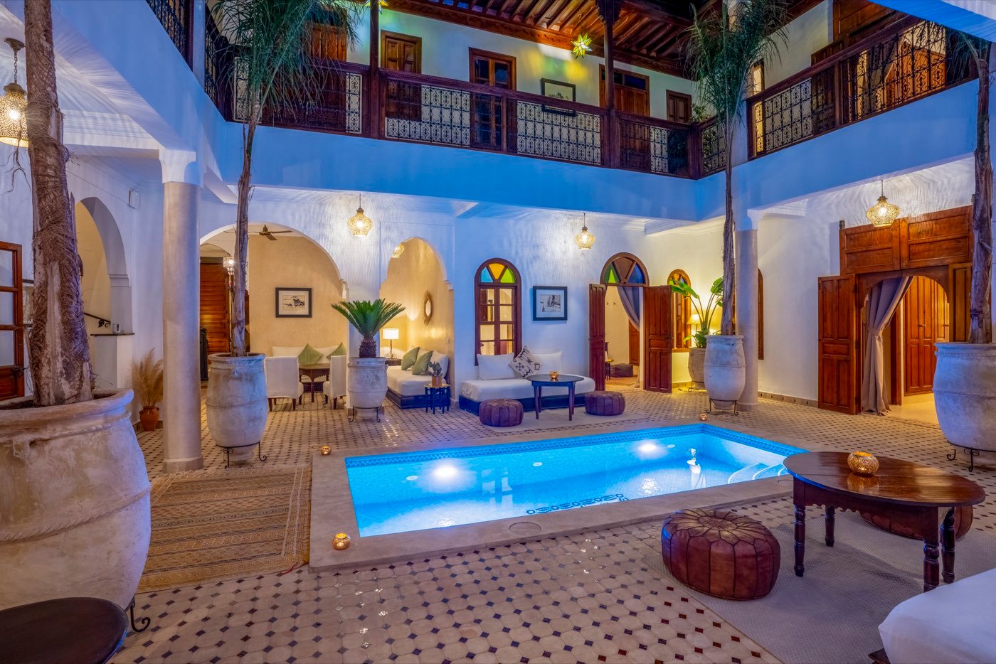 The courtyard at dusk, the pool lit from within and the walls turned blue