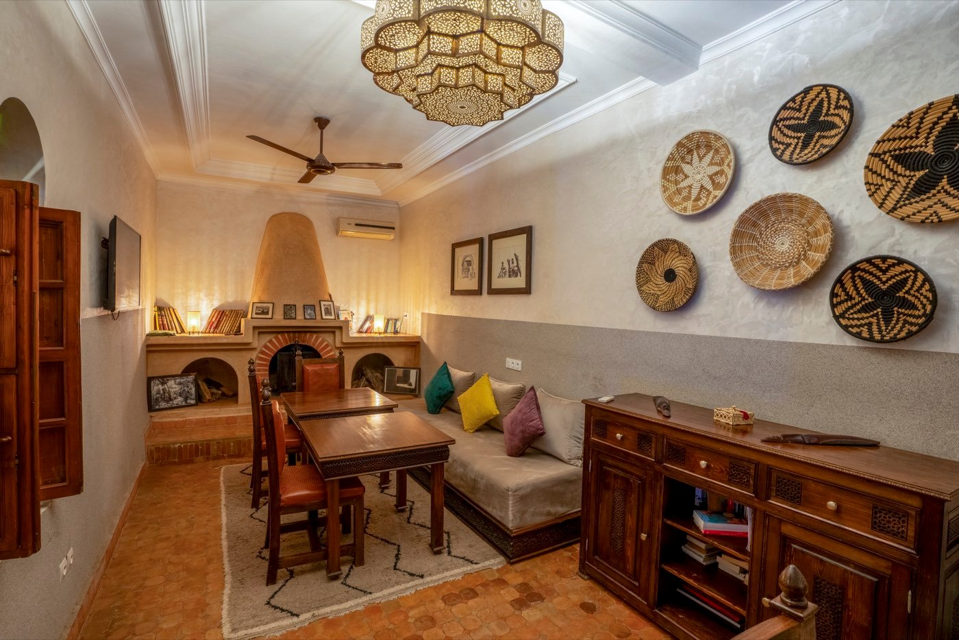 The dining room, with its corner fireplace and woven baskets on the wall