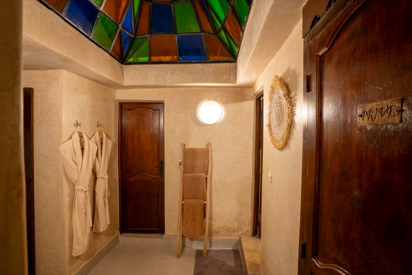 The private changing room, with robes and towels waiting beneath a stained-glass lantern