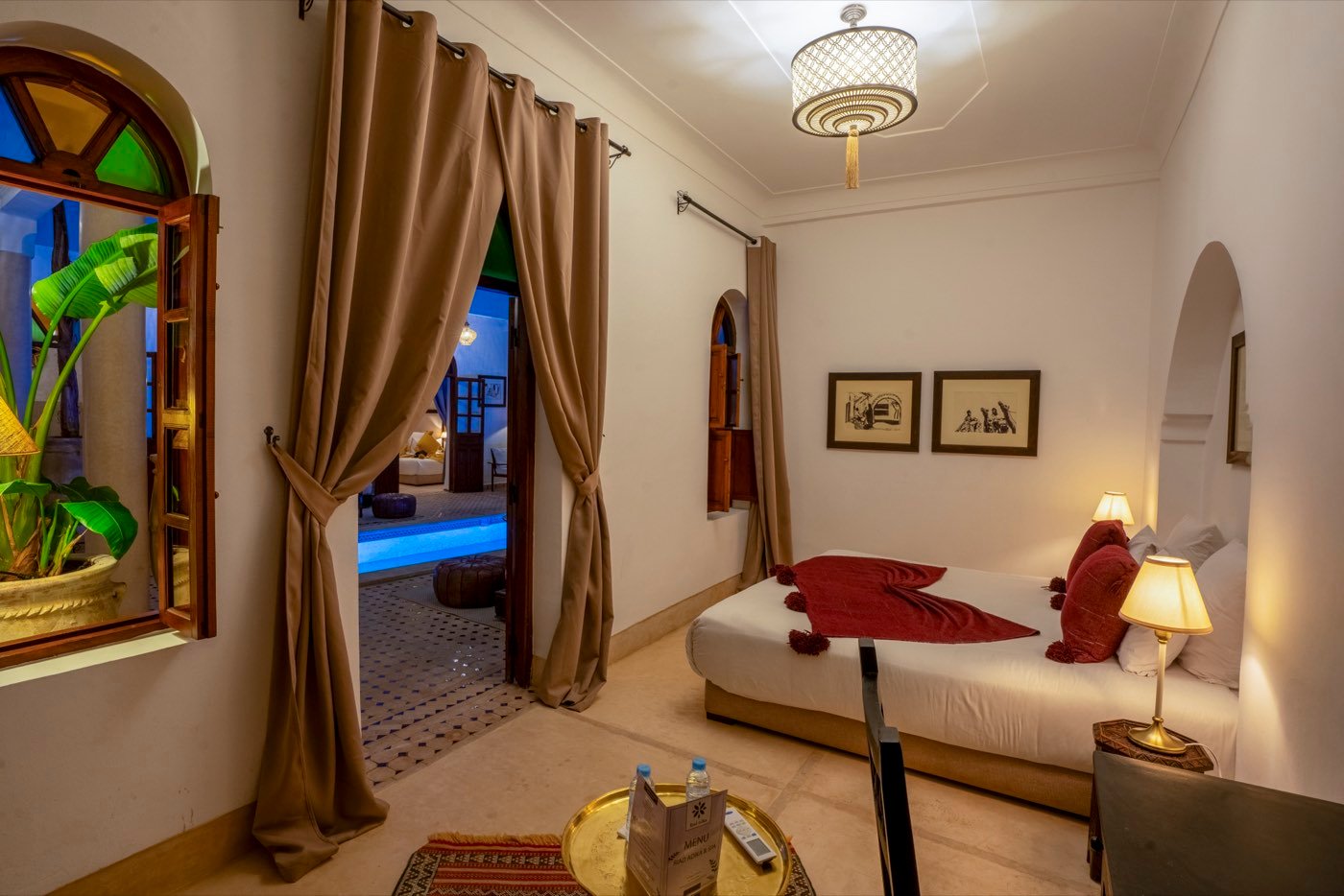 A Superior room at night, its doorway open to the lit courtyard